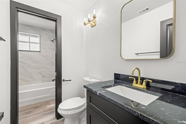 full bathroom with vanity, tiled shower / bath combo, hardwood / wood-style flooring, and toilet