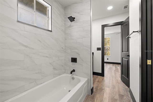 bathroom featuring tiled shower / bath and wood-type flooring