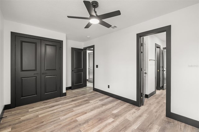 unfurnished bedroom featuring light hardwood / wood-style floors, a closet, and ceiling fan