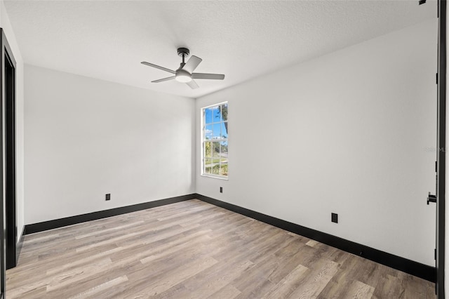 empty room with ceiling fan, a textured ceiling, and light wood-type flooring