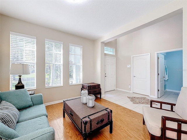 living room with a textured ceiling and light wood-type flooring