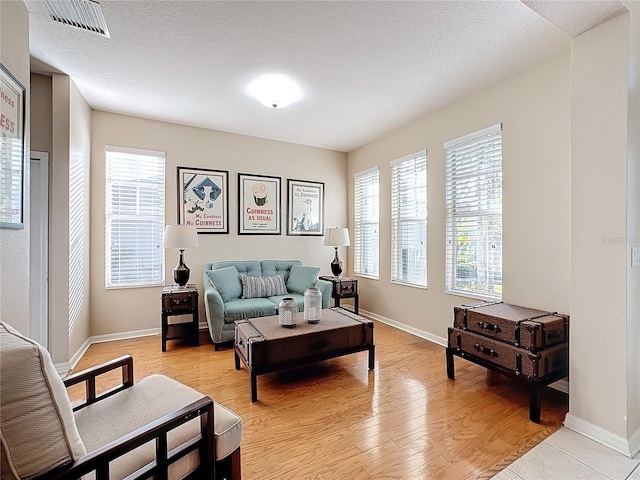 living room with a textured ceiling and light wood-type flooring