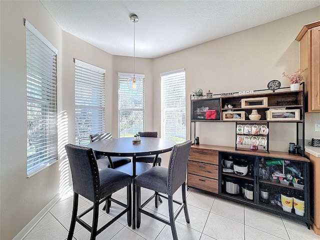 dining room featuring a textured ceiling and light tile patterned floors