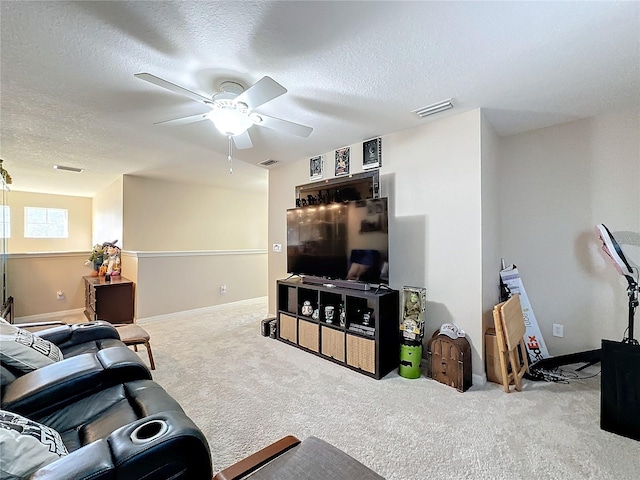 carpeted living room featuring a textured ceiling and ceiling fan