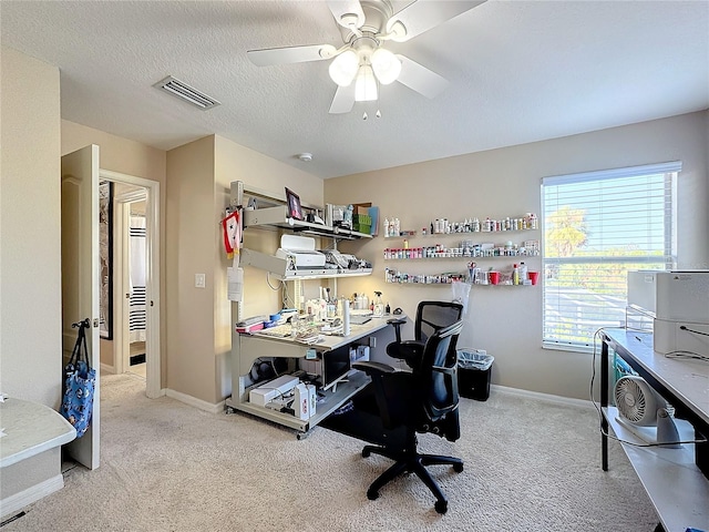 home office featuring a textured ceiling, light colored carpet, and ceiling fan