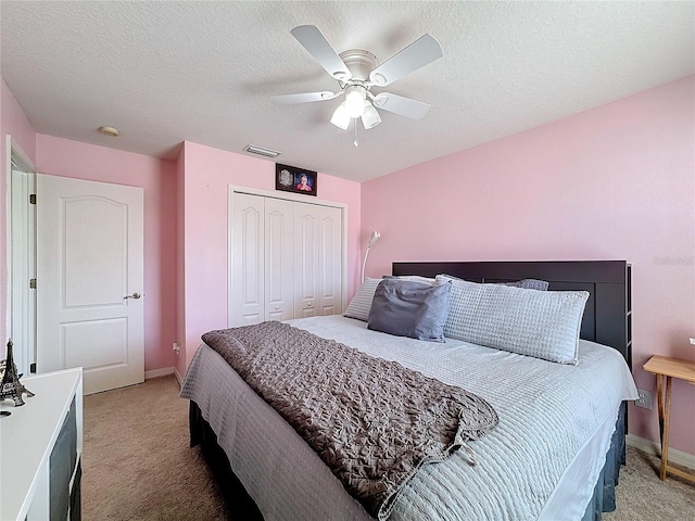 bedroom featuring a closet, carpet floors, a textured ceiling, and ceiling fan