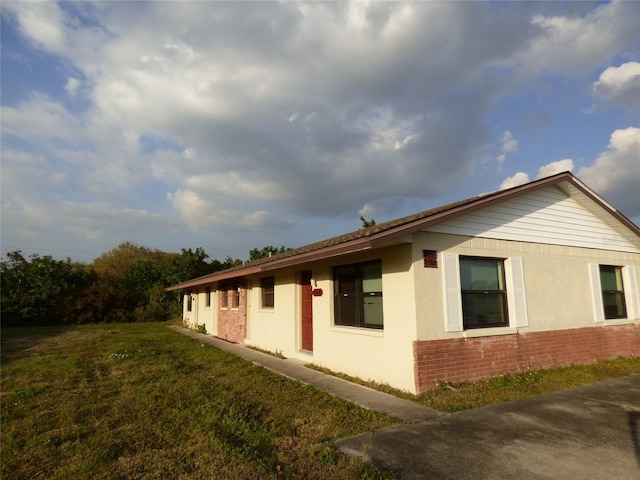 27242 Sunnybrook Rd Unit B, Punta Gorda, FL 33983 - view of property exterior with brick siding and a yard