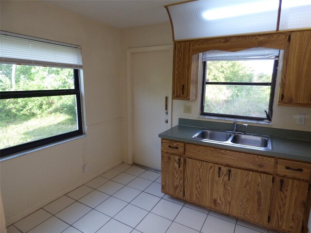 27242 Sunnybrook Rd Unit B, Punta Gorda, FL 33983 - kitchen featuring a sink, brown cabinetry, light tile patterned floors, and dark countertops