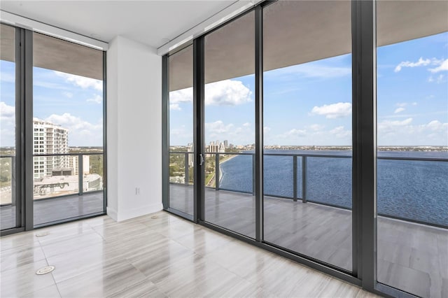 unfurnished room with a water view and floor to ceiling windows