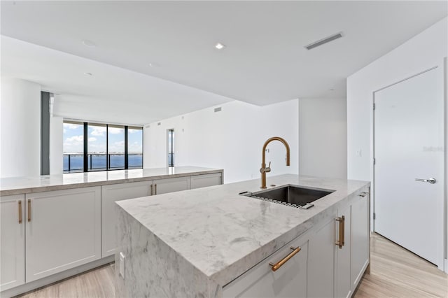 2912 W Santiago St Unit 1901, Tampa, FL 33629 - kitchen with a sink, light wood finished floors, a center island with sink, light stone countertops, and floor to ceiling windows