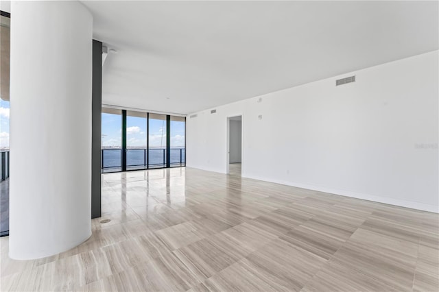 empty room featuring expansive windows and a water view