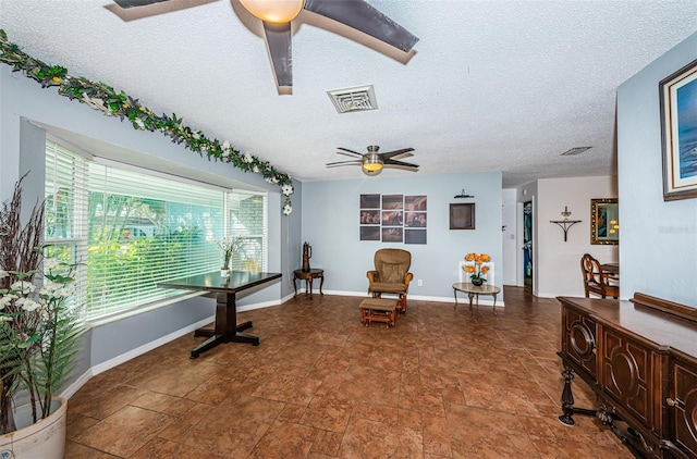 sitting room with a textured ceiling and ceiling fan