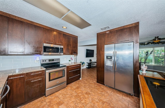 kitchen featuring backsplash, ceiling fan, light stone counters, and appliances with stainless steel finishes