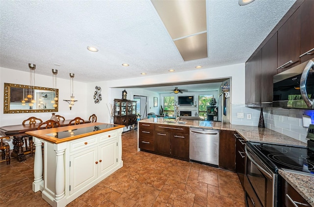 kitchen featuring stainless steel appliances, dark brown cabinetry, decorative light fixtures, and tasteful backsplash