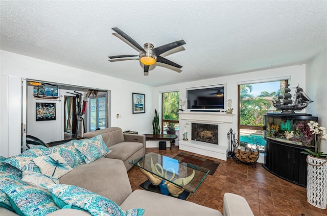 living room featuring a textured ceiling, a healthy amount of sunlight, and ceiling fan