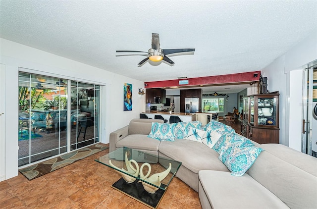 living room featuring a textured ceiling and ceiling fan