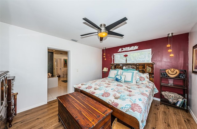 bedroom featuring ensuite bathroom, hardwood / wood-style floors, and ceiling fan