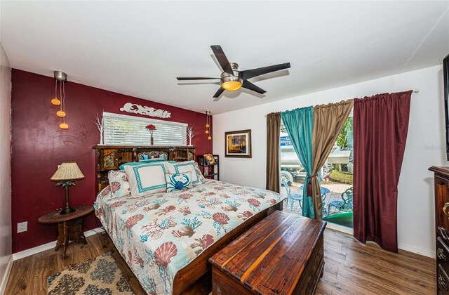 bedroom featuring access to outside, dark hardwood / wood-style floors, and ceiling fan