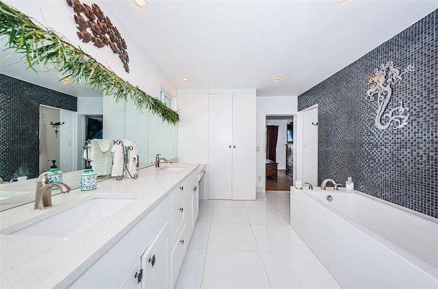13191 92nd Ave, Seminole, FL 33776 - full bathroom with an accent wall, double vanity, tile walls, tile patterned floors, and a garden tub