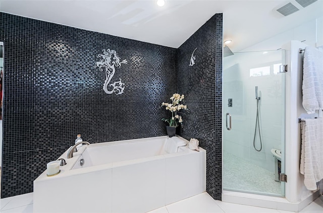 bathroom with independent shower and bath, tile patterned flooring, and tile walls