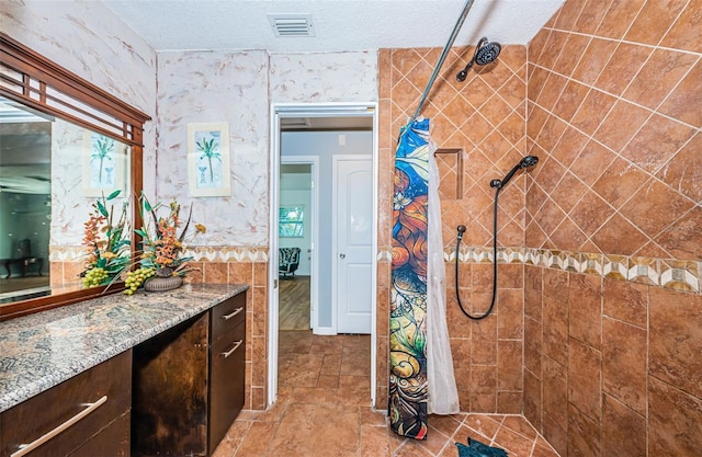 bathroom featuring vanity, a textured ceiling, and curtained shower