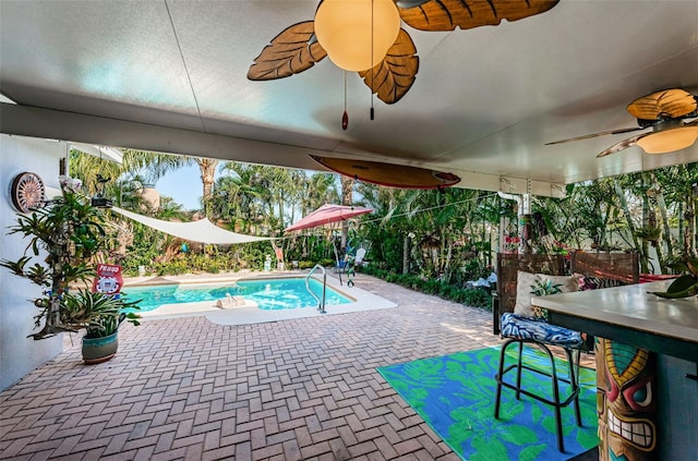 view of swimming pool with ceiling fan and a patio