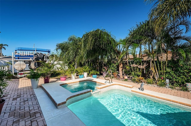 view of pool with a patio area and an in ground hot tub