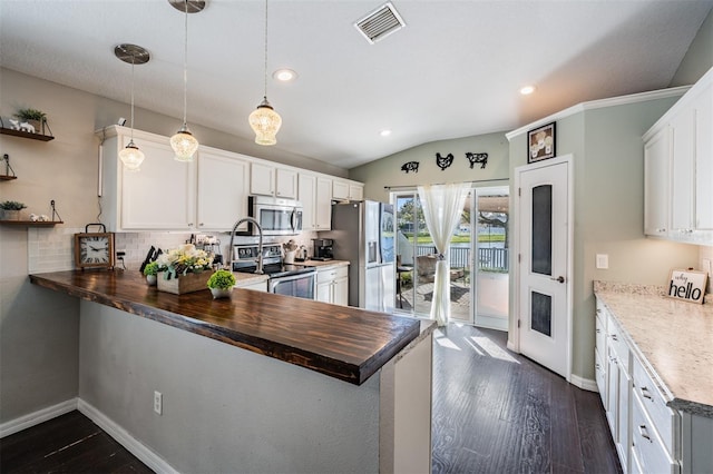 kitchen with kitchen peninsula, white cabinetry, pendant lighting, stainless steel appliances, and butcher block countertops