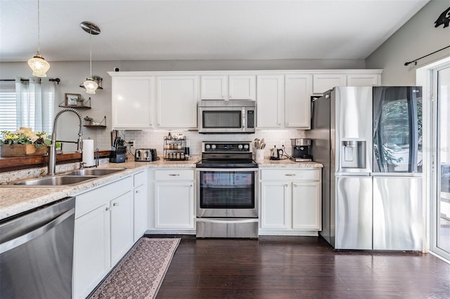 kitchen with stainless steel appliances, sink, decorative light fixtures, white cabinets, and dark hardwood / wood-style flooring