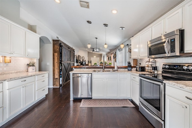 kitchen featuring appliances with stainless steel finishes, kitchen peninsula, dark hardwood / wood-style floors, and white cabinets