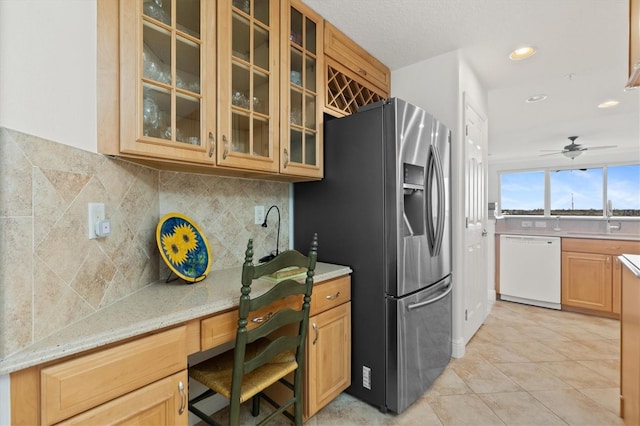 kitchen with ceiling fan, stainless steel fridge with ice dispenser, backsplash, white dishwasher, and built in desk