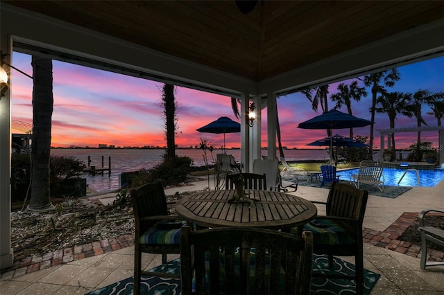 patio terrace at dusk featuring a water view