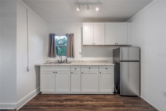 kitchen featuring white cabinets, sink, and stainless steel refrigerator