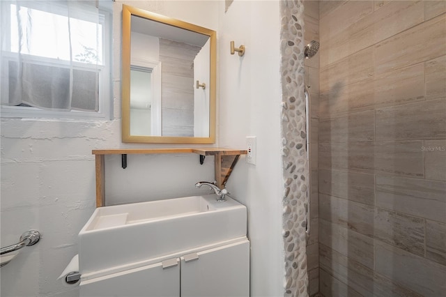 bathroom featuring vanity and tiled shower