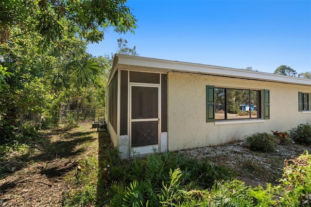 view of side of home with a sunroom