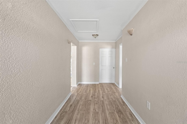 hall with light hardwood / wood-style flooring and ornamental molding