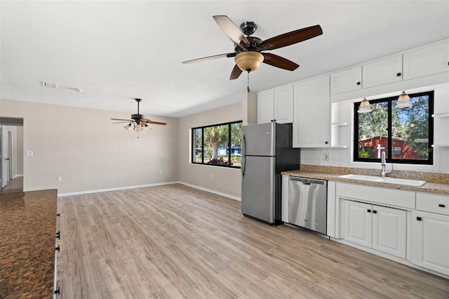 kitchen with tasteful backsplash, stainless steel appliances, sink, light hardwood / wood-style flooring, and white cabinetry