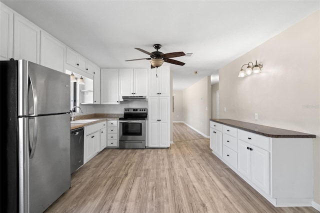 kitchen with white cabinets, sink, appliances with stainless steel finishes, and light hardwood / wood-style flooring