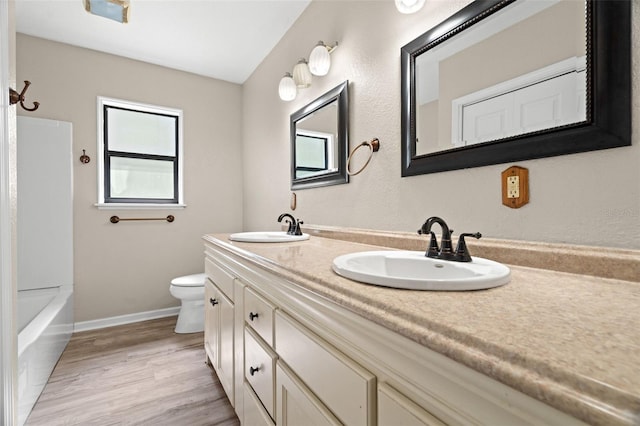 full bathroom featuring bathing tub / shower combination, vanity, wood-type flooring, and toilet