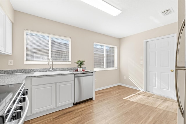 kitchen featuring sink, white cabinetry, stainless steel appliances, and light wood-type flooring