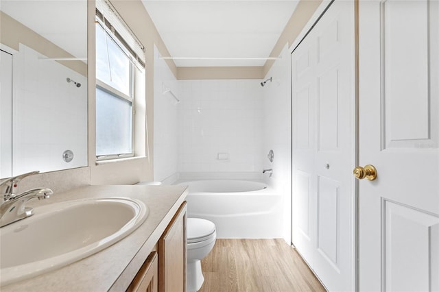 full bathroom featuring hardwood / wood-style floors, vanity, toilet, and tiled shower / bath combo