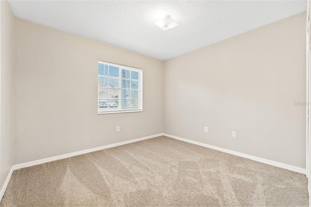 carpeted empty room with a textured ceiling