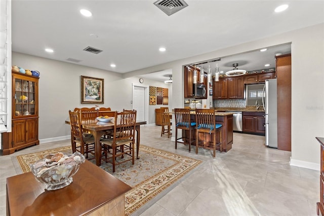 tiled dining space with ceiling fan