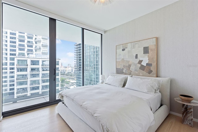 bedroom featuring access to exterior and wood-type flooring