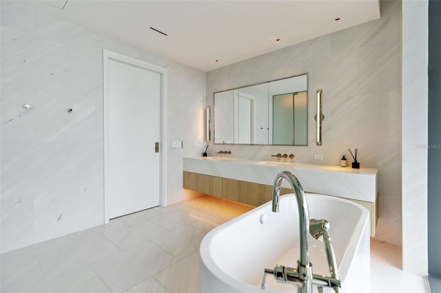 bathroom with vanity, tile walls, and a washtub