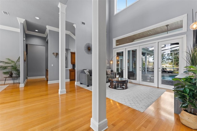 entrance foyer featuring a high ceiling, decorative columns, and hardwood / wood-style floors