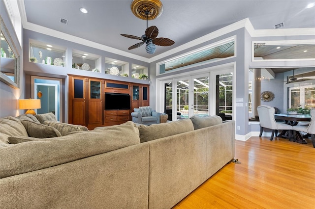 living room with hardwood / wood-style floors, ceiling fan, french doors, and crown molding