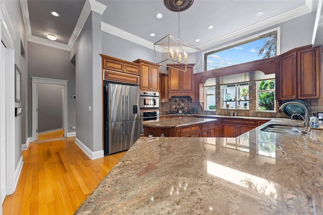 kitchen with tasteful backsplash, light stone countertops, appliances with stainless steel finishes, and light hardwood / wood-style floors