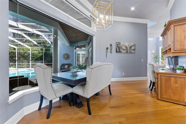 dining space with a notable chandelier, crown molding, and light hardwood / wood-style flooring