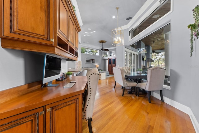 interior space with ceiling fan with notable chandelier and light hardwood / wood-style floors